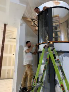 A Custom Renovators employee installing a pneumatic vacuum elevator in a Long Island home