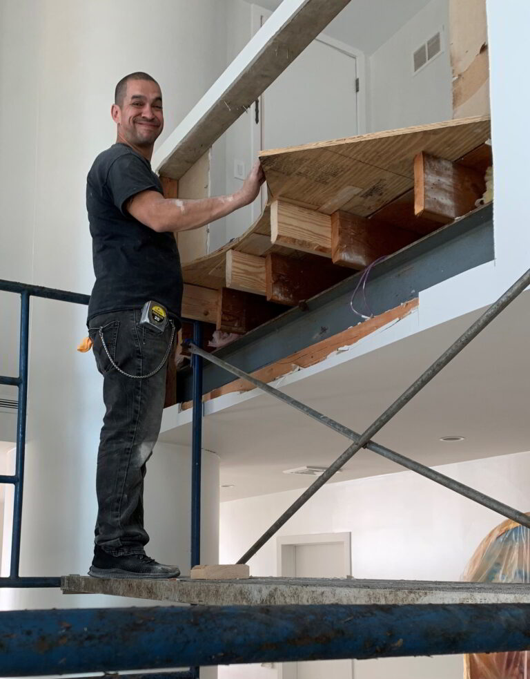 A Custom Renovators of New York Inc. employee helping to install a Pneumatic Vacuum Elevator in a customer's house