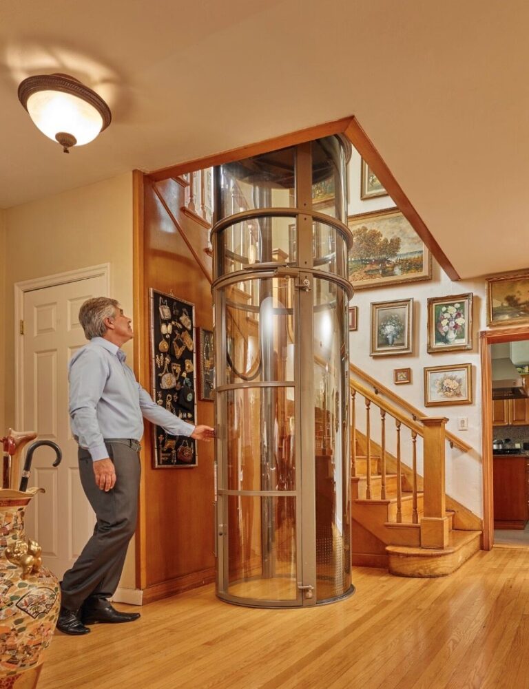 A man stands in front of a residential vacuum elevator